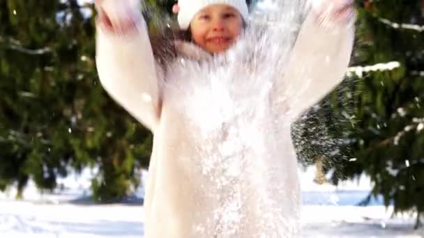 Glad liten flicka kastar snö i vinter park — Stockvideo