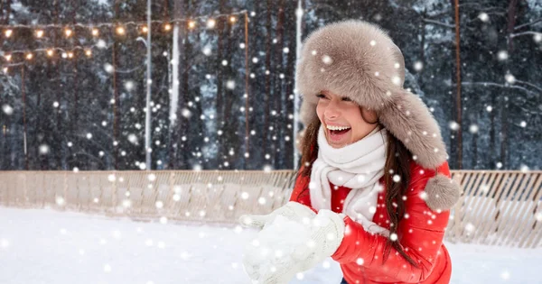 Ευτυχισμένη γυναίκα με χιόνι στο χειμερινό καπέλο στο παγοδρόμιο — Φωτογραφία Αρχείου