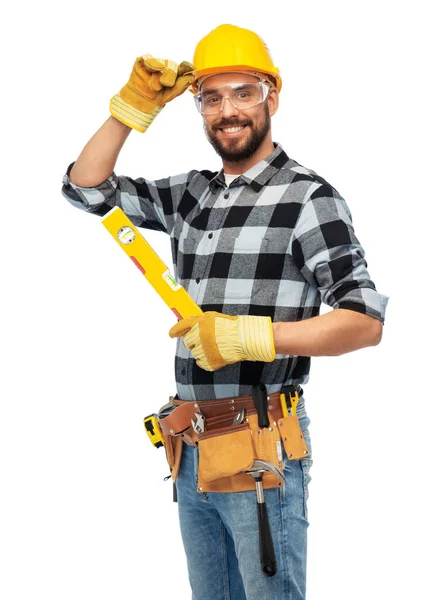 Счастливый мужчина работник или строитель в шлеме с уровнем — стоковое фото