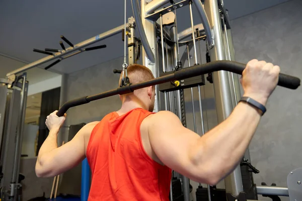 Spor salonundaki kablo makinesinde egzersiz yapan adama yaklaş. — Stok fotoğraf