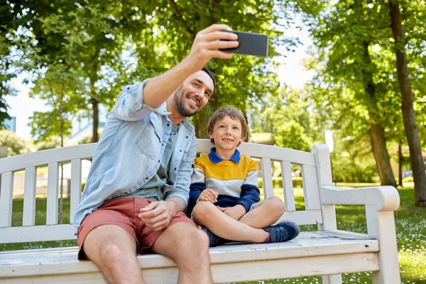 Πατέρας και γιος βγάζουν selfie με το τηλέφωνο στο πάρκο — Φωτογραφία Αρχείου