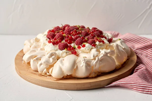 Tarta de merengue pavlova con bayas sobre tabla de madera — Foto de Stock