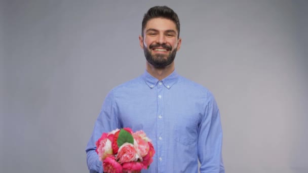 Счастливый улыбающийся молодой человек с букетом цветов — стоковое видео