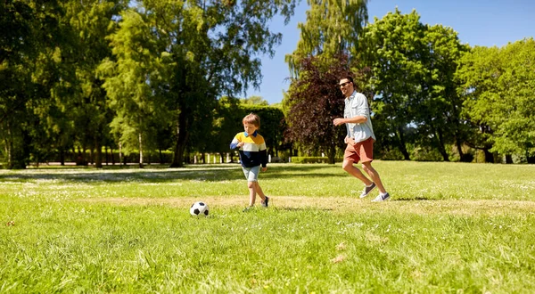 Otec s malým synem hraje fotbal v parku — Stock fotografie