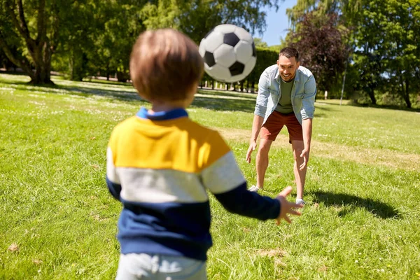 Padre con hijo pequeño jugando al fútbol en el parque — Foto de Stock