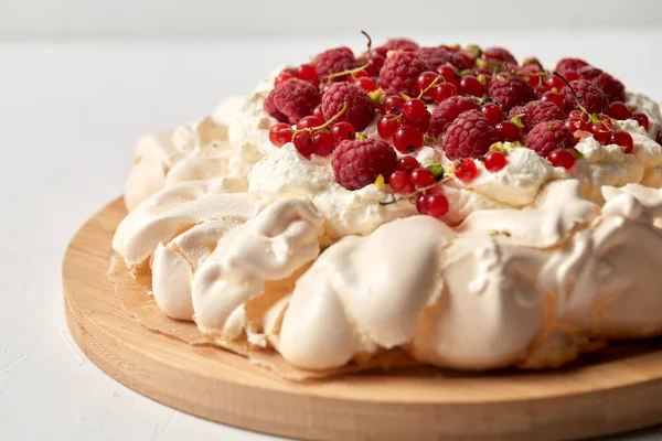 Tarta de merengue pavlova con bayas sobre tabla de madera — Foto de Stock