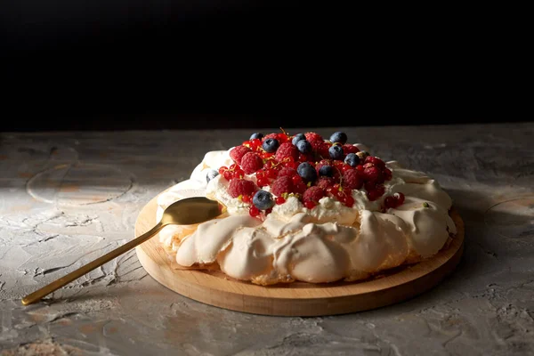 Tarta de merengue pavlova con bayas sobre tabla de madera —  Fotos de Stock