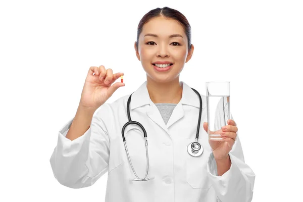 Asiatischer Arzt mit Medizin und Glas Wasser — Stockfoto