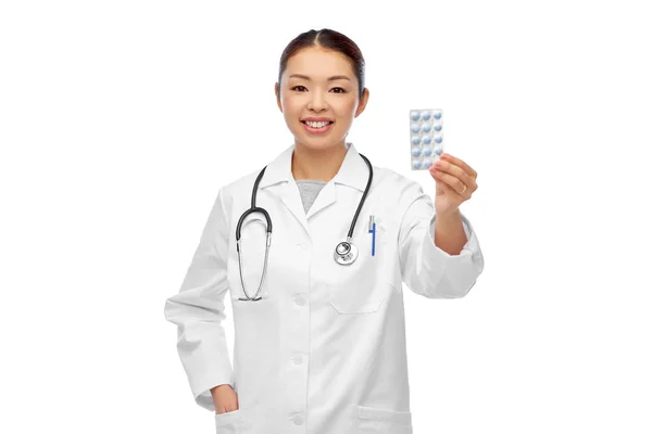 Happy asian female doctor or nurse with medicine — Stock Photo, Image
