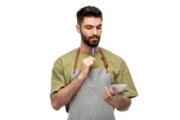 Waiter in apron taking notes to notepad — Stock Photo, Image