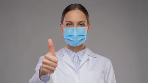 Femme médecin dans le masque médical montrant pouces vers le haut — Video