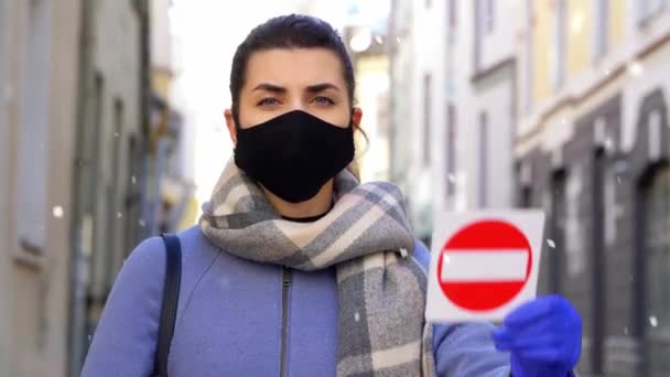 Kobieta w masce twarzy ze znakiem stopu w zimowym mieście — Wideo stockowe