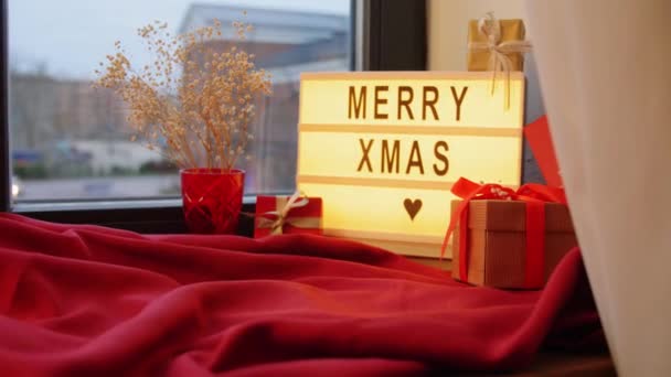 Joyeux noël sur boîte à lumière et cadeaux sur la fenêtre — Video