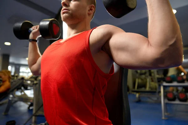 Primer plano del hombre con pesas haciendo ejercicio en el gimnasio —  Fotos de Stock