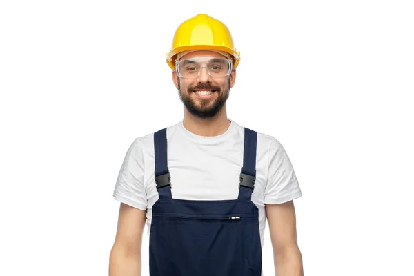 Happy male worker or builder in helmet and overall — Stock Photo, Image