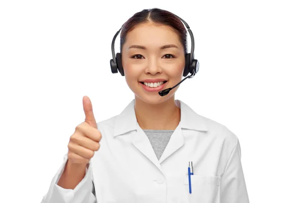 Sorrindo asiático feminino médico ou enfermeira no fone de ouvido — Fotografia de Stock