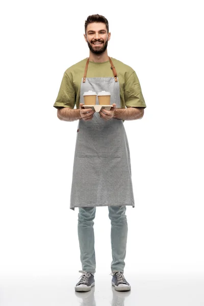 Happy smiling barman in apron with takeaway coffee — Stock Photo, Image