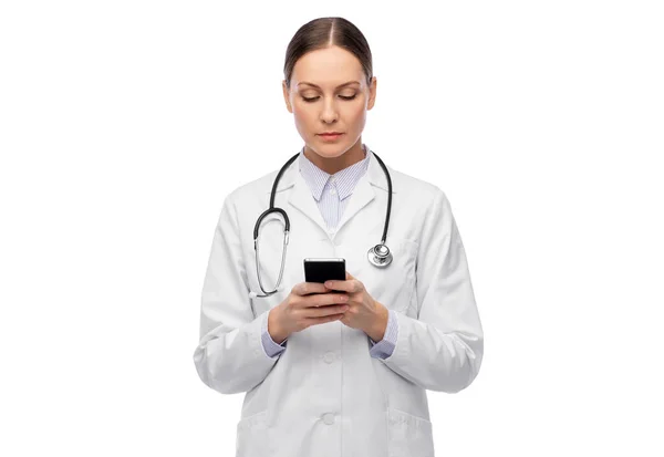 Steteskoplu bayan doktor akıllı telefon kullanıyor. — Stok fotoğraf