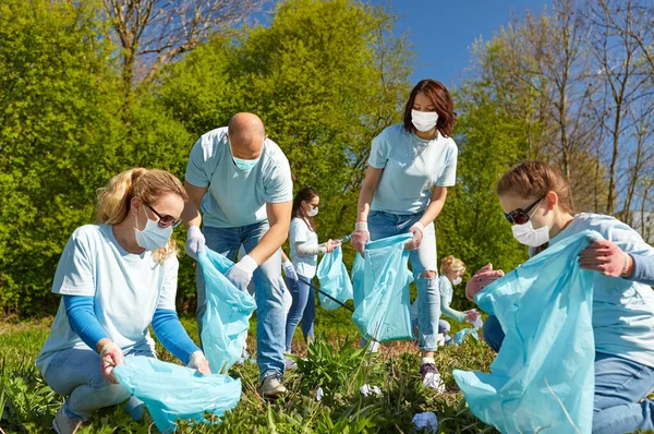 Önkéntesek maszkban, szemetet takarítva a parkban — Stock Fotó