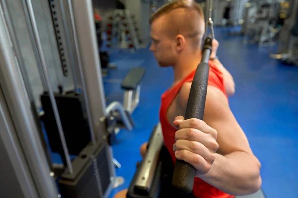 Primer plano del hombre haciendo ejercicio en la máquina de cable en el gimnasio — Foto de Stock