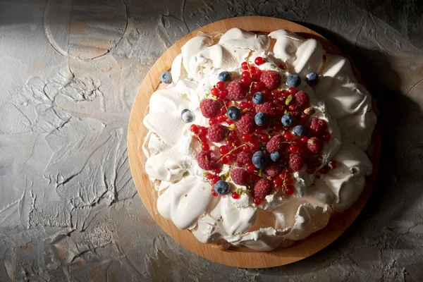 Torta di meringa pavlova con bacche su tavola di legno — Foto Stock