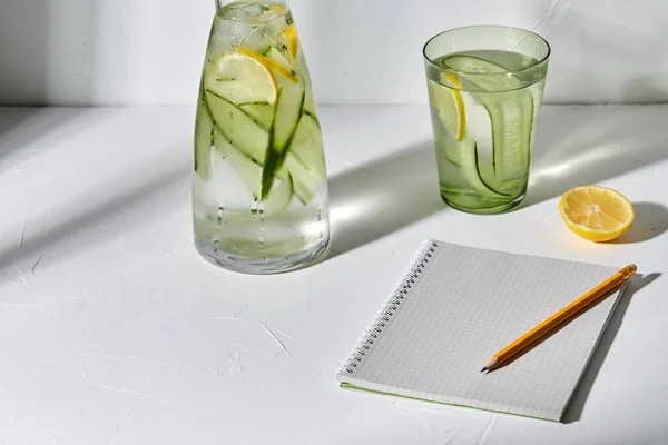 Νερό με λεμόνι και αγγούρι και σημειωματάριο — Φωτογραφία Αρχείου