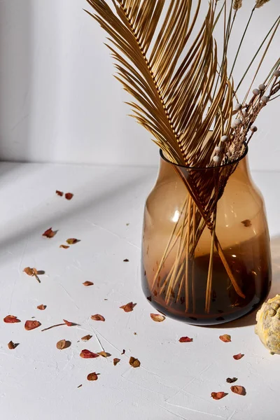 Decorative dried flowers in glass vase and petals — Stock Photo, Image