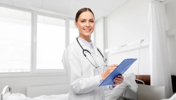 Smiling female doctor with clipboard at hospital Royalty Free Stock Images