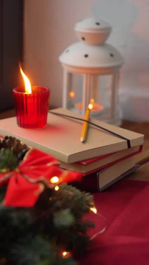 Christmas wreath, books, candle, lantern on window — Stock Video