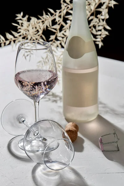 Verres à vin et bouteille de champagne ombres tombantes — Photo