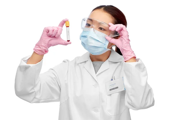 Asian female doctor holding beaker with blood test — Stock Photo, Image