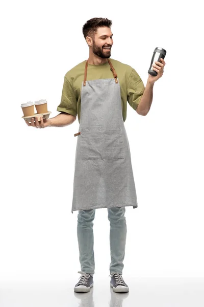 Happy waiter with takeout coffee cups and tumbler — Stock Photo, Image