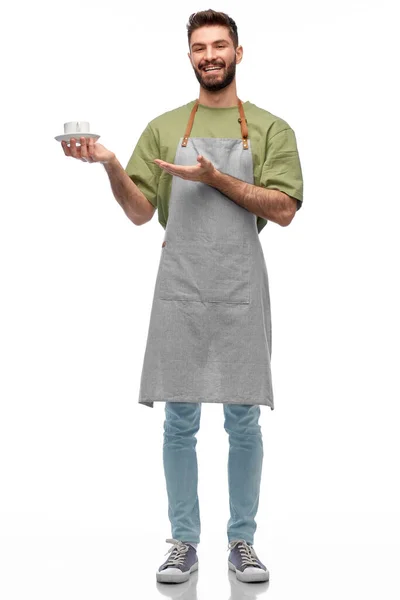 Happy smiling waiter in apron with cup of coffee — Stock Photo, Image