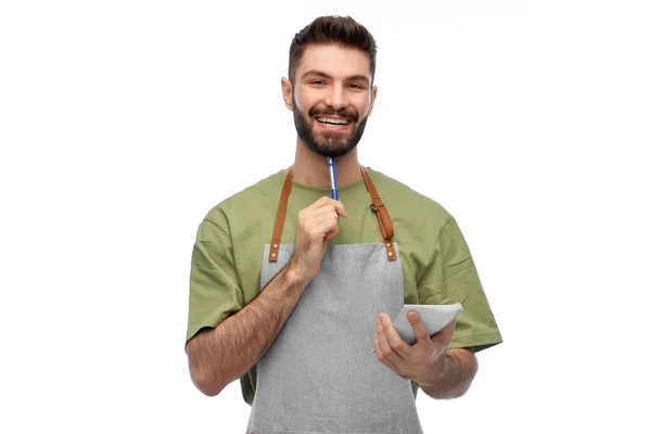 Smiling waiter in apron with pen and notepad — Stock Photo, Image