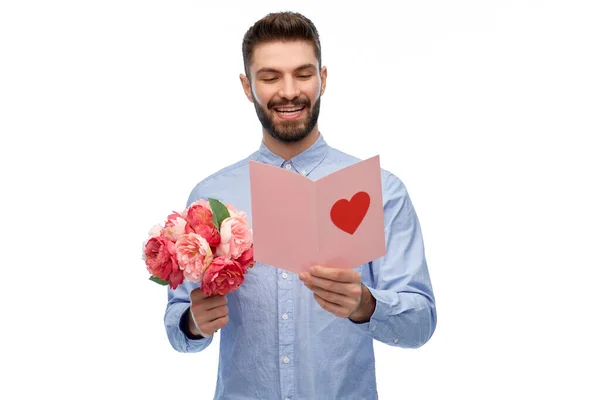 Glücklicher Mann mit Blumen und Valentinstag-Karte — Stockfoto