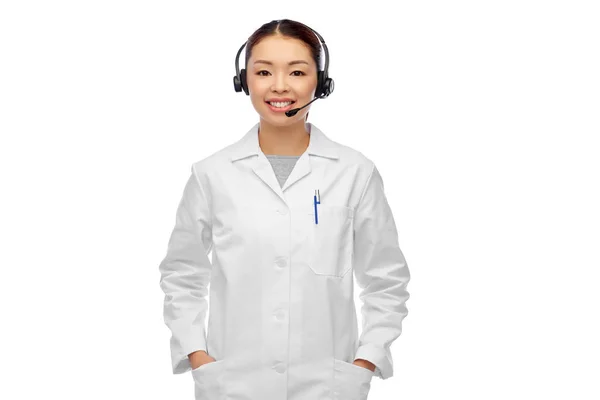 Sonriente asiático mujer médico o enfermera en auriculares — Foto de Stock