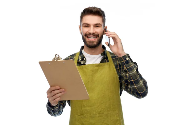 Man trädgårdsmästare med Urklipp ringer på smartphone — Stockfoto