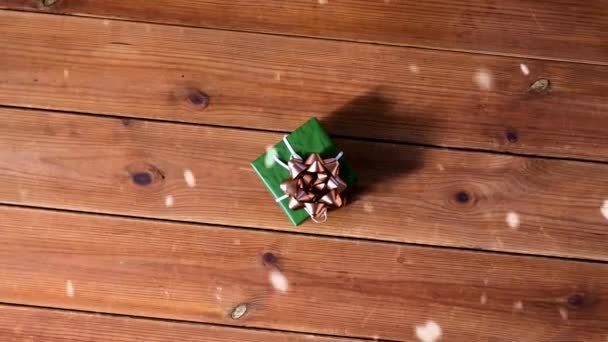 Pudełko prezentów w zielonym opakowaniu z łukiem drewniane deski — Wideo stockowe