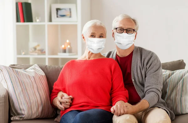 Senioren paar in maskers op kerst thuis — Stockfoto