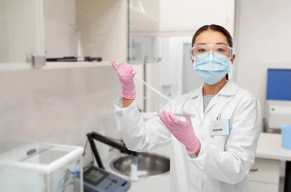 Asiatische Wissenschaftlerin in Maske arbeitet an Impfstoff — Stockfoto