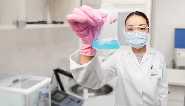 Asiatischer Arzt oder Wissenschaftler in Maske mit Fläschchen — Stockfoto