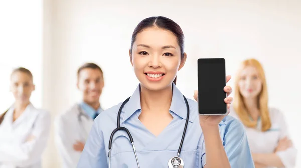 Glücklich asiatische Ärztin oder Krankenschwester mit Smartphone — Stockfoto