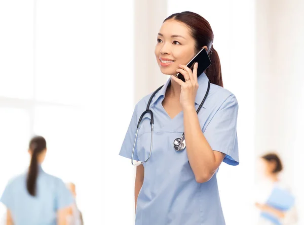 Asiatische Krankenschwester telefoniert im Krankenhaus mit Smartphone — Stockfoto