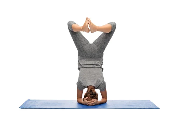 Woman making yoga in headstand pose on mat — Stock Photo, Image