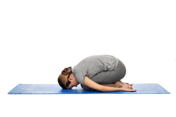 Woman doing yoga child pose on mat — ストック写真