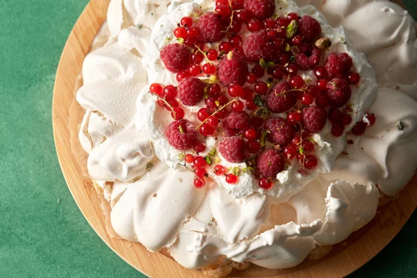 Tarta de merengue pavlova con bayas sobre tabla de madera —  Fotos de Stock