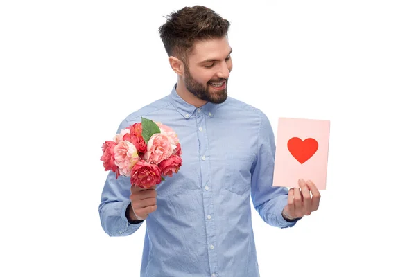 Glücklicher Mann mit Blumen und Valentinstag-Karte — Stockfoto