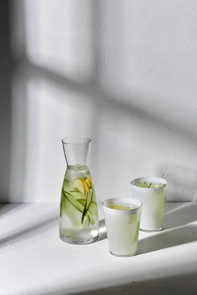 Glas med citronvatten och gurka på bordet — Stockfoto