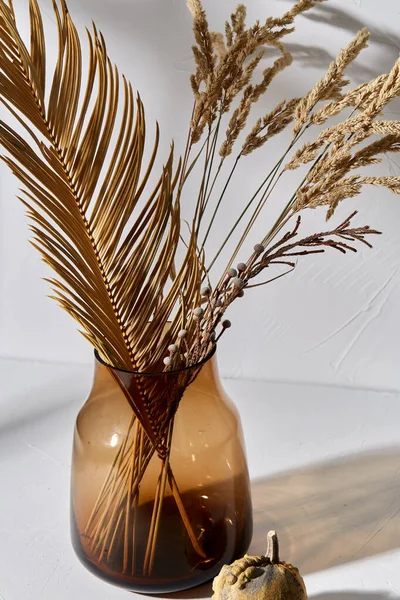 Fiori secchi decorativi in vaso di vetro e zucca — Foto Stock