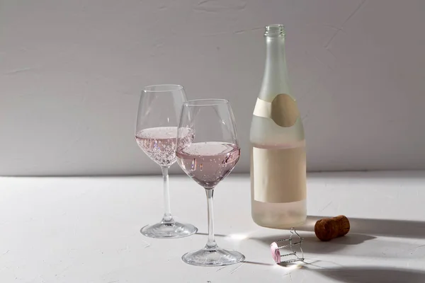 Verres à vin et bouteille de champagne ombres tombantes — Photo